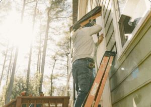 Man installing a window frame outside