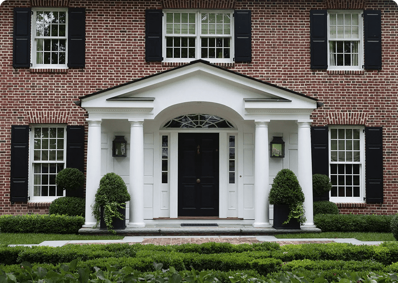 Colonial-style house facade with black shutters.